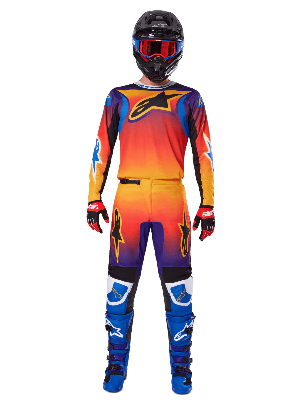Alpinestars Pantaloni Fluid Wurx 2025, pantaloni da motocross, sfumatura multicolore arancione, giallo e viola, indossati con maglia coordinata, casco nero con occhiali blu, guanti rossi e neri e stivali blu, abbigliamento da gara motocross coordinato