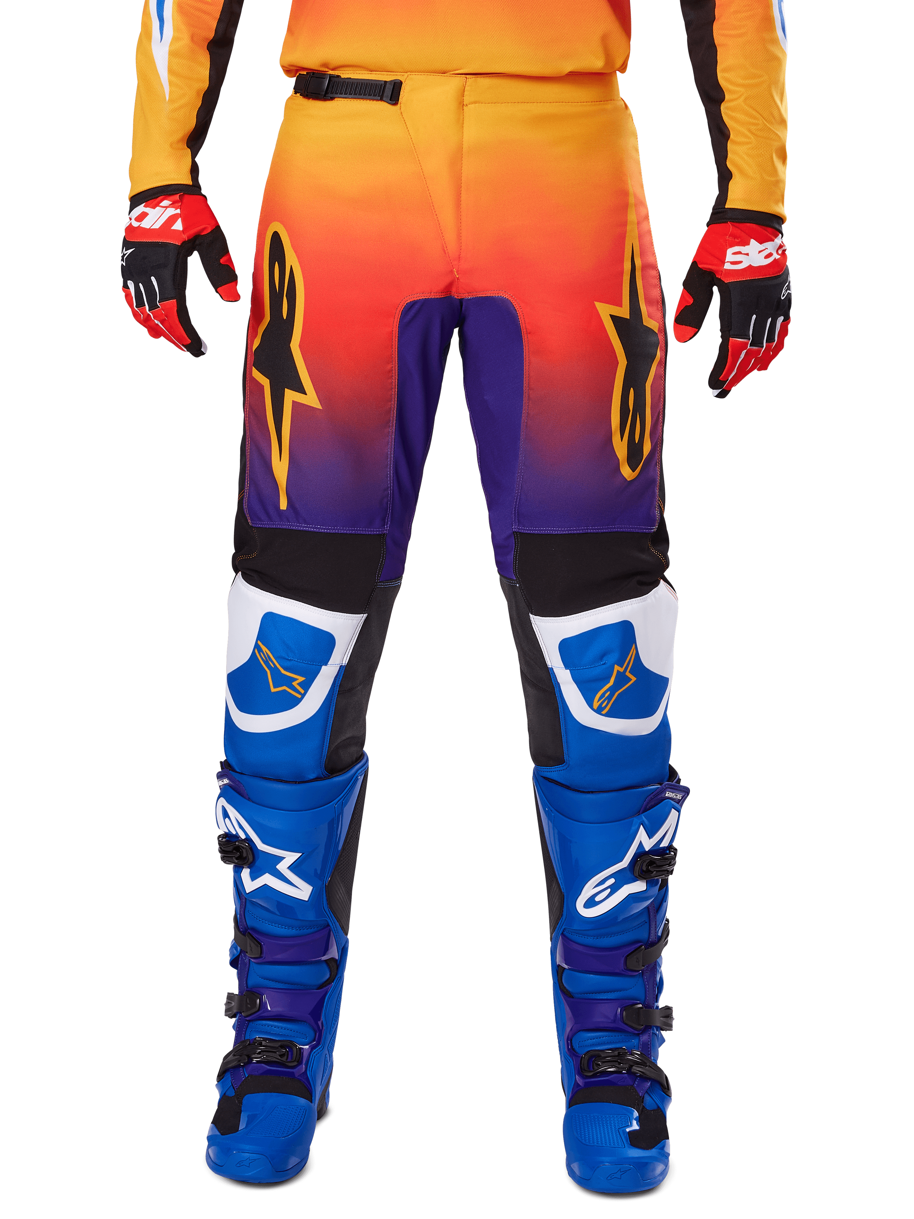 Alpinestars Pantaloni Fluid Wurx 2025, pantaloni da motocross, multicolore con sfumatura dall'arancione al viola e inserti blu, indossati con stivali blu e viola coordinati e guanti rossi e neri, vista frontale con logo a stella