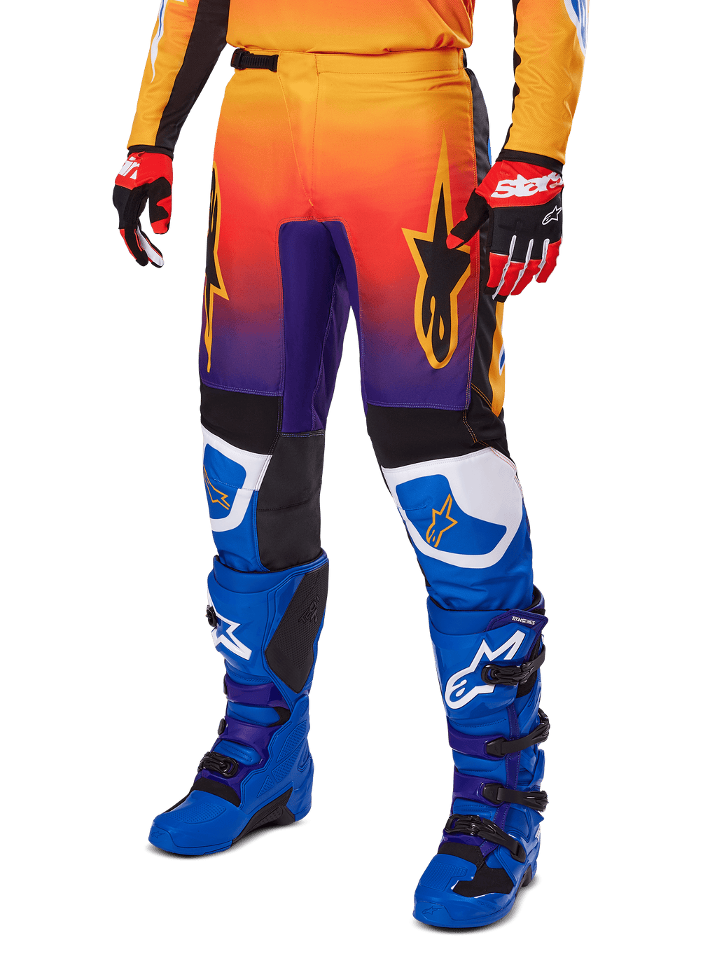 Alpinestars 2025 Fluid Wurx Pants, pantaloni da motocross, sfumatura multicolore arancione, rossa e viola con pannelli neri e blu, indossati con stivali blu e guanti rossi, con grafica del logo a stella e dettagli bianchi sulle ginocchia, abbigliamento tecnico resistente per fuoristrada
