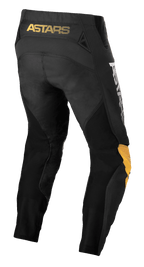 Alpinestars Pantaloni Techstar Quadro, pantaloni da motocross, nero, giallo e mandarino, vista posteriore con marchio 'ASTARS' giallo sulla cintura, inserti in rete nera per la ventilazione e pannelli ergonomici sulle ginocchia in giallo e mandarino per la resistenza nel fuoristrada