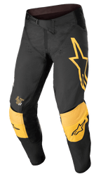 Alpinestars Techstar Quadro Pants, pantaloni da motocross fuoristrada, nero e giallo con accenti tangerine, grande logo a stella giallo sulla coscia sinistra, protezioni ginocchia gialle rinforzate con loghi neri, fori di ventilazione e chiusura a cricchetto in vita per una vestibilità da gara ad alte prestazioni.