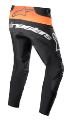 Alpinestars Techstar Sein Pants 2023, pantaloni da motocross, nero e arancione acceso, vista posteriore con pannello in vita arancione e logo nero, grande marchio Alpinestars bianco sulla seduta, costruzione in tessuto rinforzato per gare fuoristrada