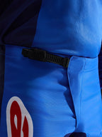 Alpinestars Pantaloni Fluid Grid 2026, pantaloni da motocross, blu e rosso, vista ravvicinata del sistema di chiusura a cricchetto nero in vita, resistente tessuto in poliestere blu con accento del logo rosso e bianco, progettati per prestazioni fuoristrada