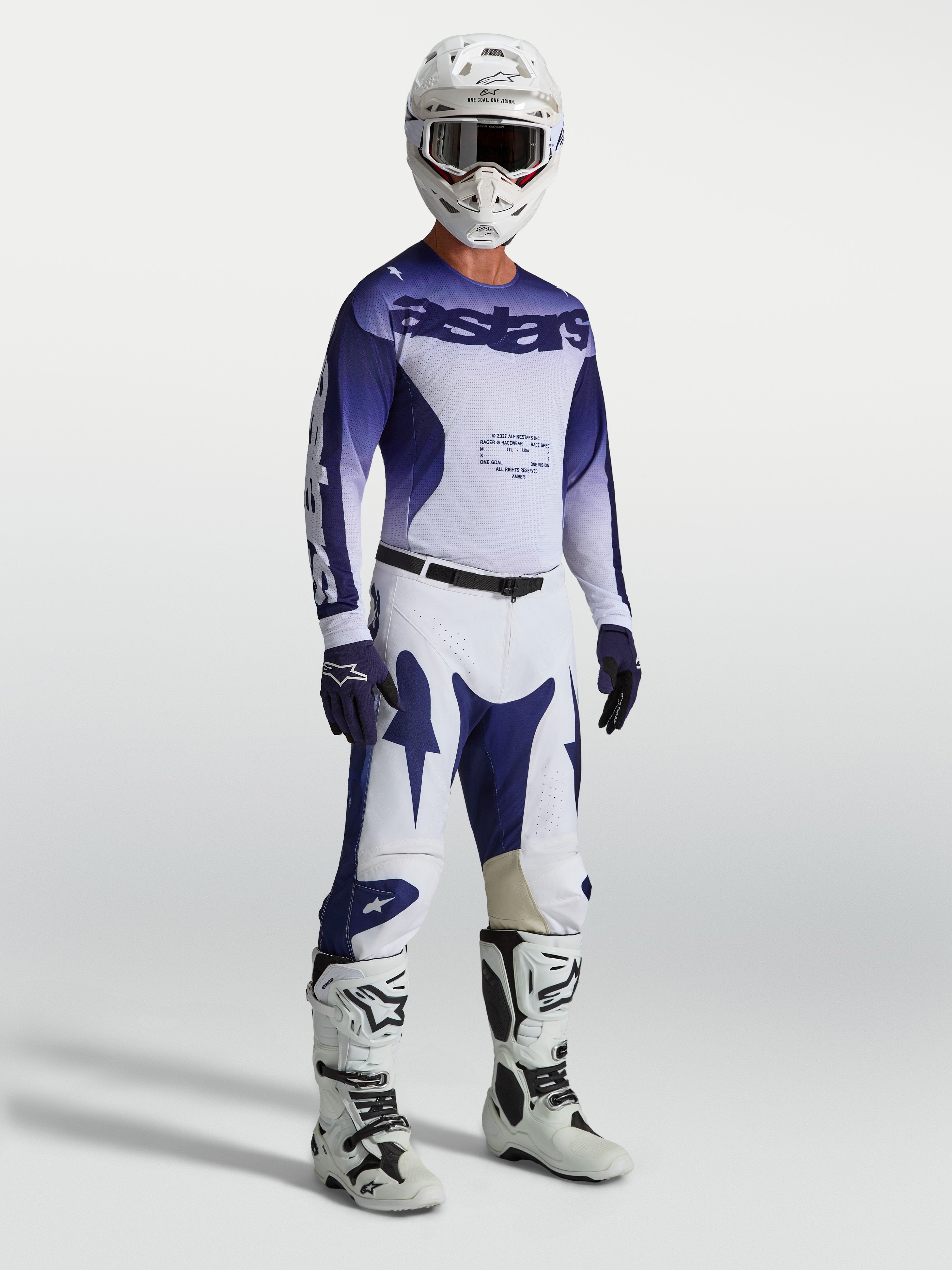 Alpinestars Pantaloni Racer Air Amber, pantaloni MX da uomo blu e bianchi su modello con maglia, stivali e casco coordinati.