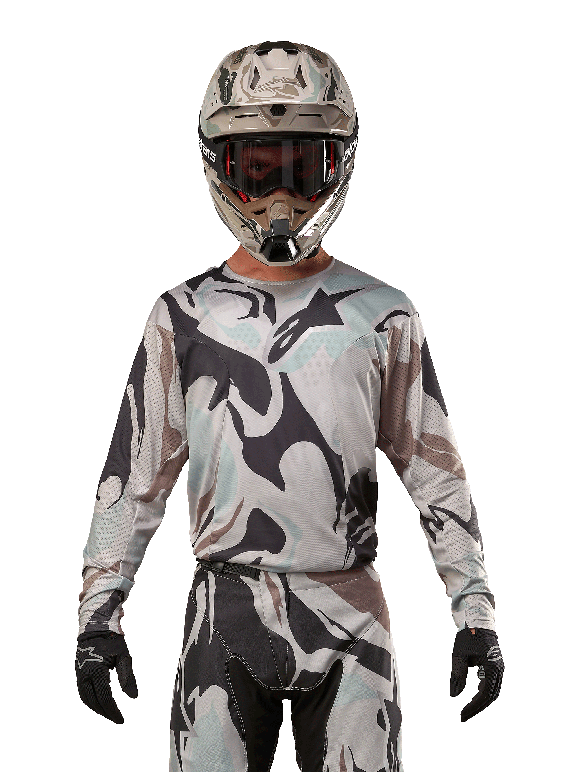Alpinestars Maglia Racer Tactical 2024, maglia da motocross, motivo mimetico Iron Camo Dust Gray, pilota che indossa casco e occhiali coordinati con guanti neri, abbigliamento tecnico per fuoristrada