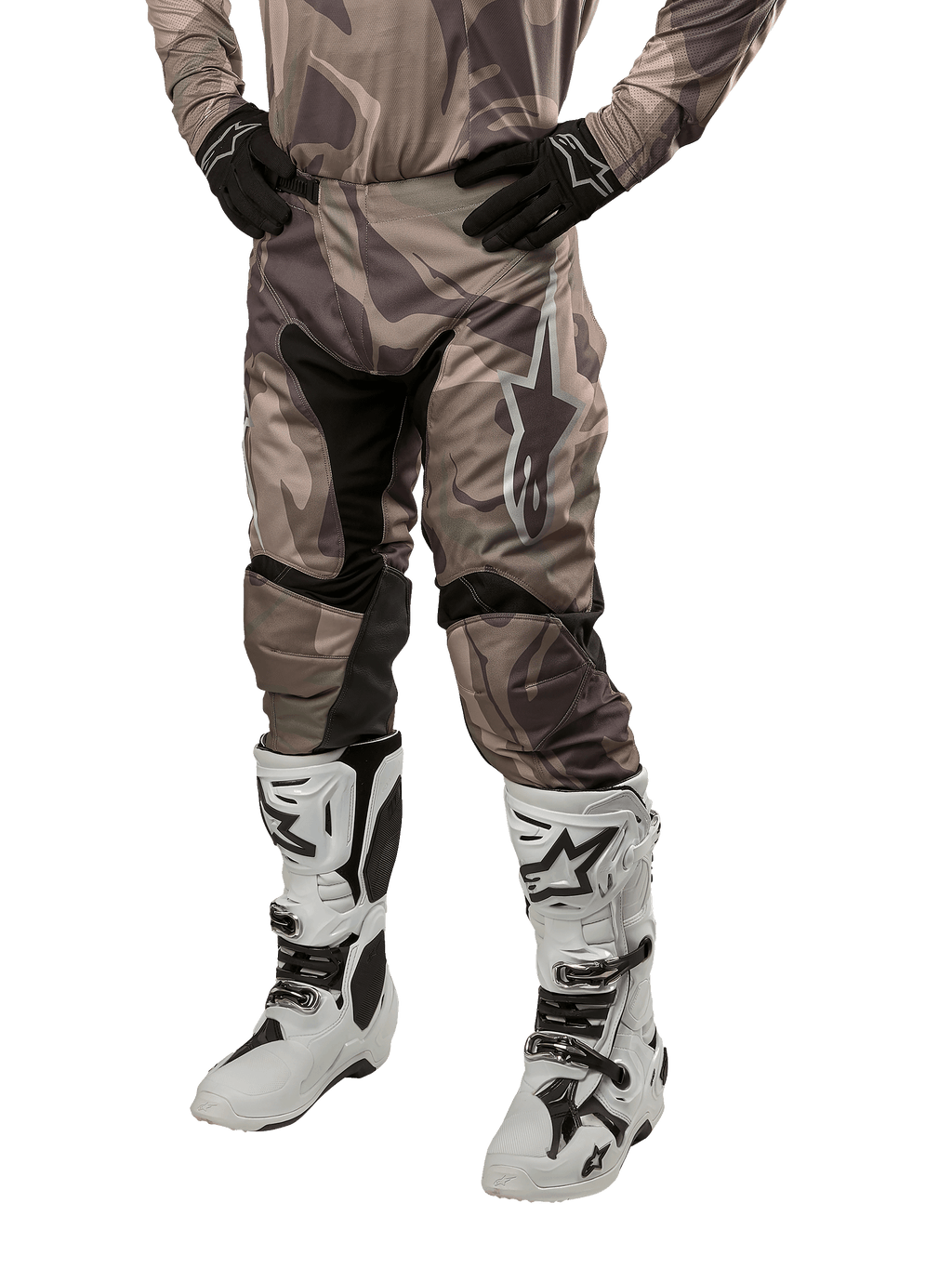 Alpinestars 2024 Racer Tactical Pants, pantaloni da motocross, mimetico verde militare e marrone, indossati con maglia mimetica coordinata, guanti neri e stivali bianchi con loghi a stella, con pannelli elastici neri e design ergonomico, kit da fuoristrada su sfondo bianco