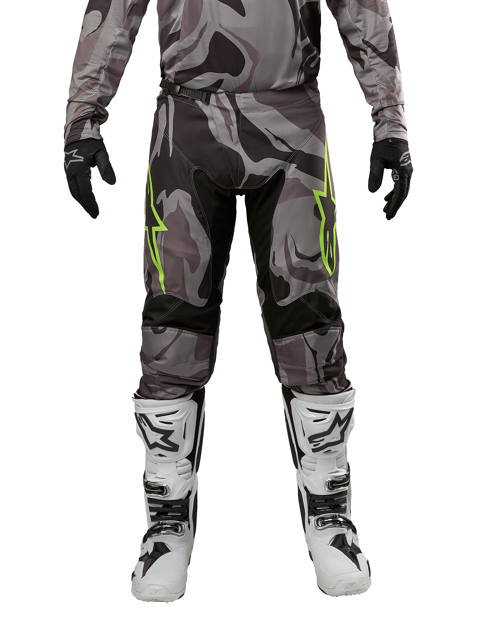 Alpinestars Pantaloni Racer Tactical 2024, pantaloni da motocross, Cast Gray Camo Magnet, indossati con maglia camo coordinata, guanti neri e stivali bianchi e neri, con loghi a stella verde lime sulle cosce e pannelli elasticizzati neri, vista frontale per equipaggiamento da fuoristrada