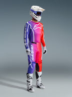 Alpinestars 2026 Fluid Apex Pants, pantaloni da motocross, sfumatura multicolore viola, rosa e arancione, indossati con maglia abbinata, casco bianco e stivali bianchi, con logo bianco e design ergonomico per corse off-road