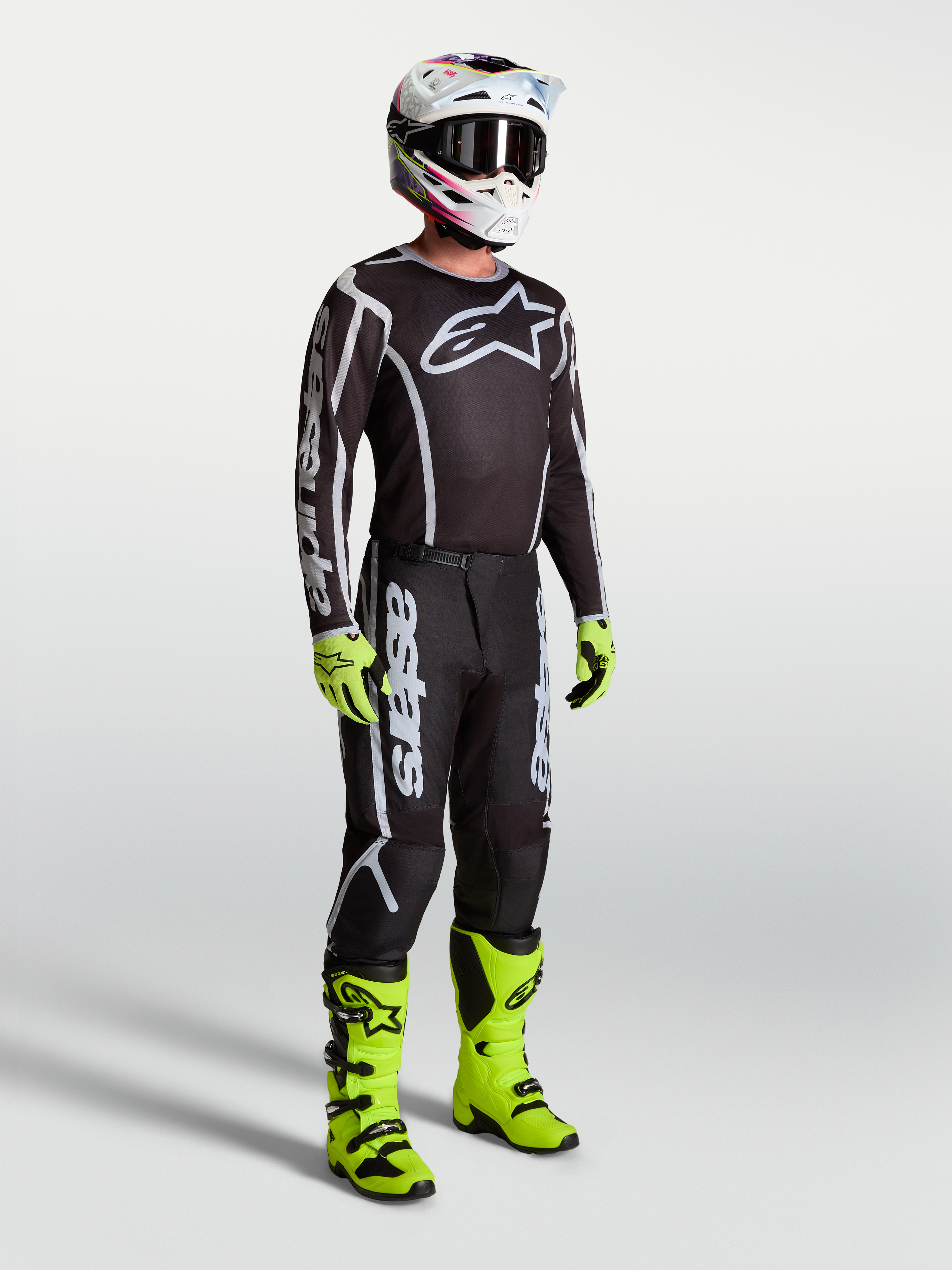 Alpinestars pantaloni Fluid Apex V2, pantaloni da motocross neri e argento, resistenti per il fuoristrada, indossati da un pilota.