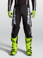 Alpinestars pantaloni da motocross Fluid Apex V2 2027 da uomo neri e argento, con pannelli stretch ergonomici su modello.