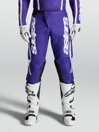 Alpinestars Pantaloni Fluid Apex V2, pantaloni motocross da uomo, blu scuro e bianco, indossati con stivali e guanti coordinati, abbigliamento fuoristrada ad alte prestazioni