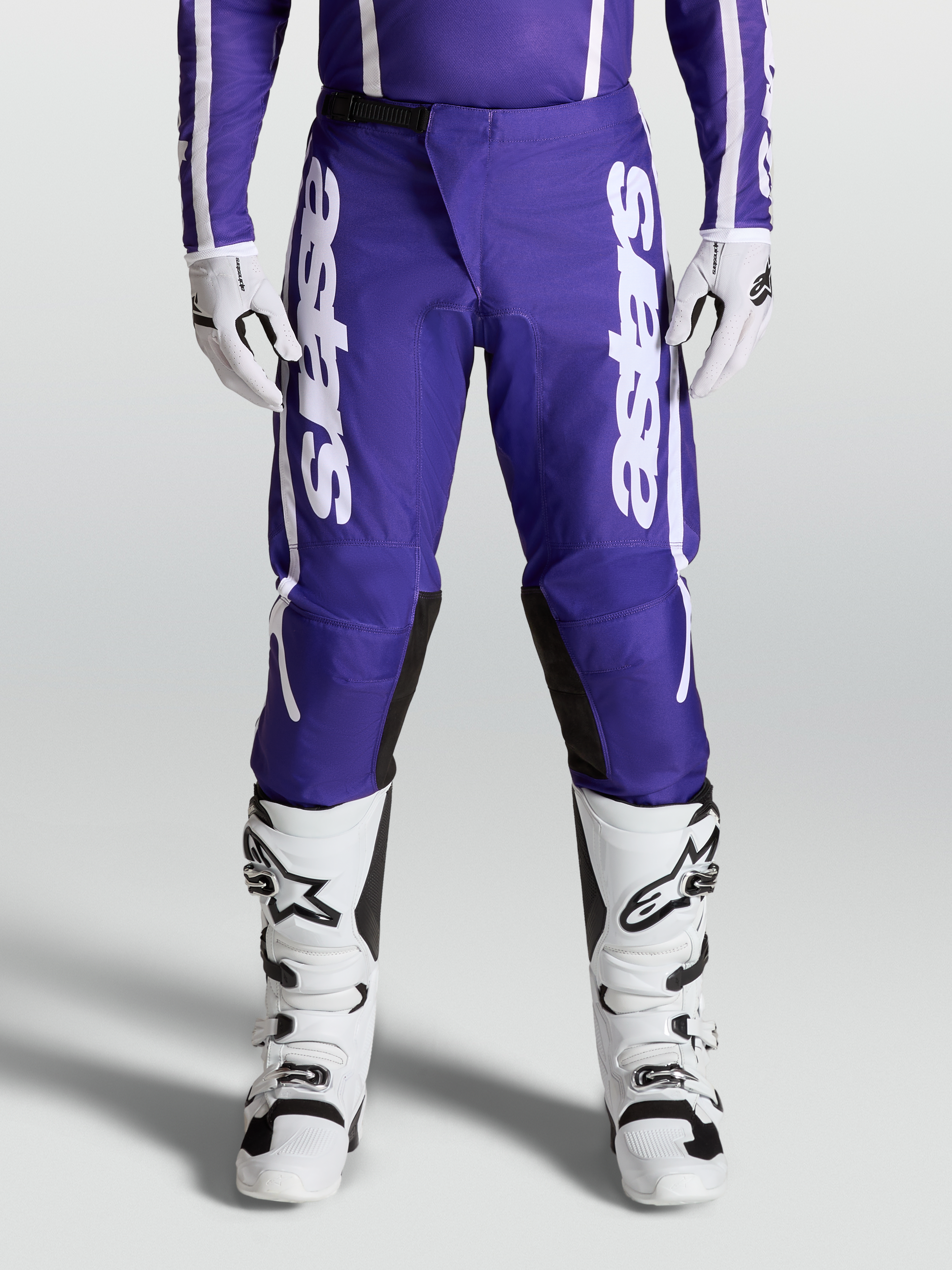 Alpinestars Pantaloni Fluid Apex V2, pantaloni motocross da uomo, blu scuro e bianco, indossati con stivali e guanti coordinati, abbigliamento fuoristrada ad alte prestazioni