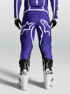 Alpinestars Pantaloni Fluid Apex V2, pantaloni motocross da uomo, blu scuro e bianchi, vista posteriore con stivali, in poliestere 600D resistente