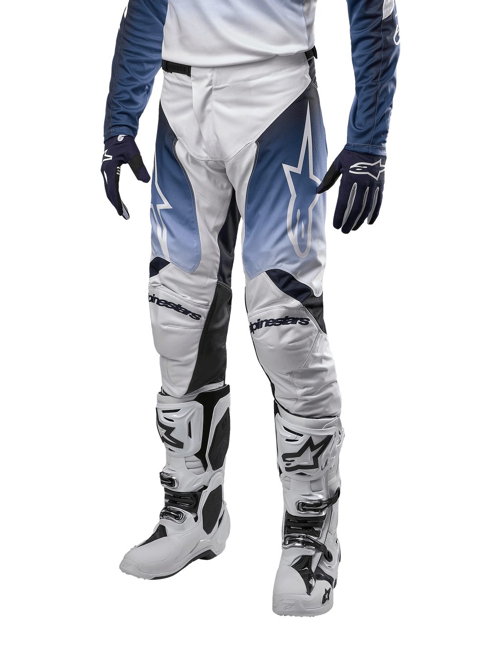 Alpinestars 2024 Racer Hoen Pants, pantaloni da motocross, bianco con sezioni blu navy e azzurro, logo a stella bianco, indossati con stivali bianchi e neri e guanti blu, abbigliamento protettivo per fuoristrada