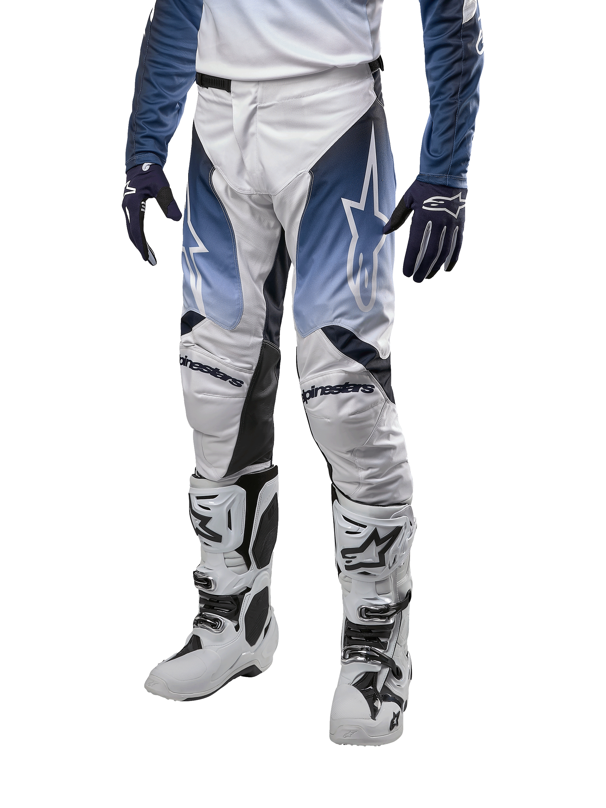 Alpinestars 2024 Racer Hoen Pants, pantaloni da motocross, bianco con sezioni blu navy e azzurro, logo a stella bianco, indossati con stivali bianchi e neri e guanti blu, abbigliamento protettivo per fuoristrada