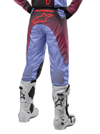 Alpinestars Racer Hoen Pants 2024, pantaloni da motocross, viola Lavan e nero, vista posteriore con grande logo a stella rosso sulla seduta, indossati con stivali da motocross bianchi, con pannelli elasticizzati traspiranti nella parte inferiore delle gambe