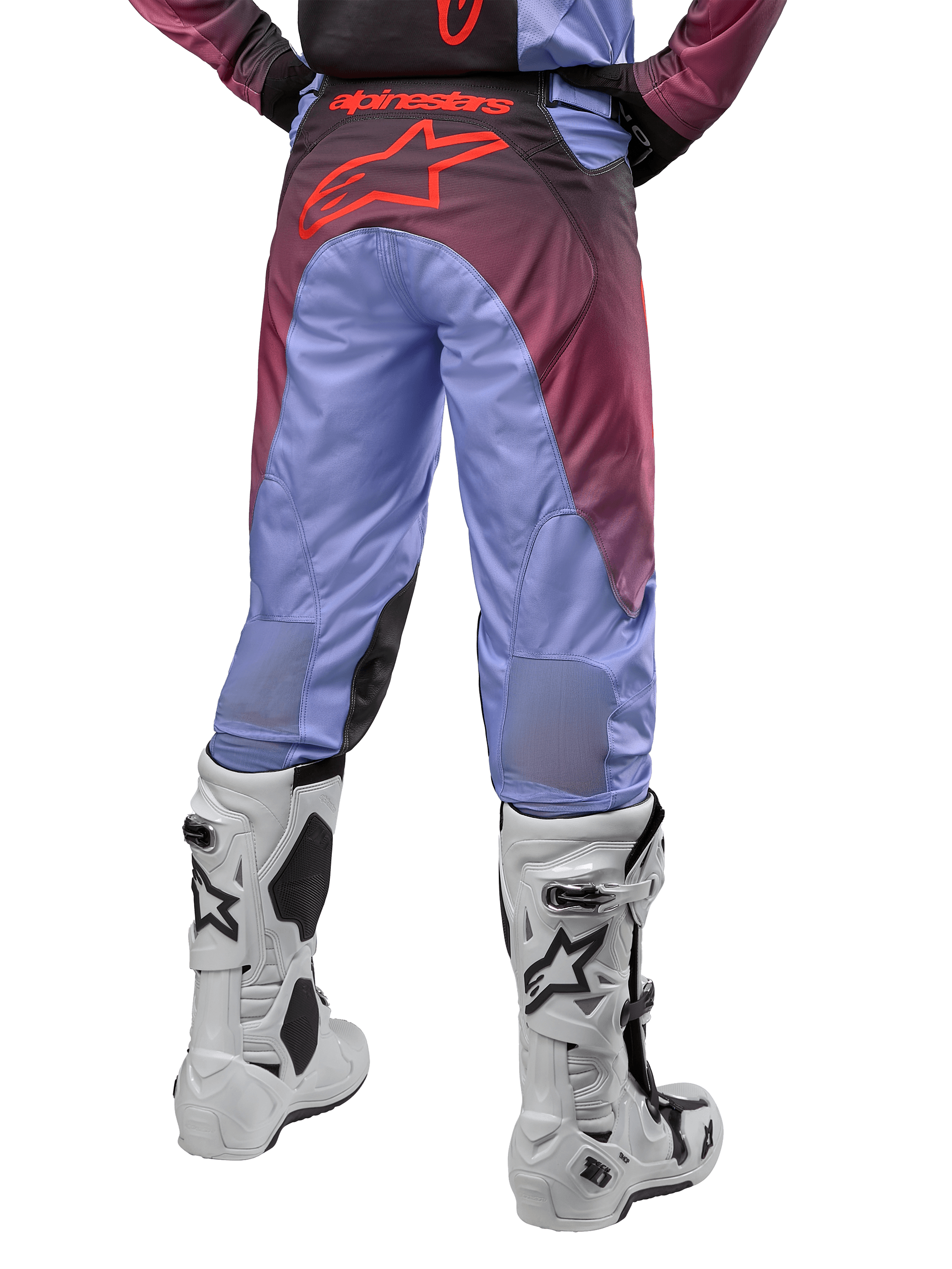 Alpinestars Racer Hoen Pants 2024, pantaloni da motocross, viola Lavan e nero, vista posteriore con grande logo a stella rosso sulla seduta, indossati con stivali da motocross bianchi, con pannelli elasticizzati traspiranti nella parte inferiore delle gambe