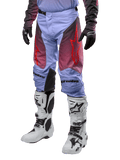 Alpinestars Racer Hoen Pants 2024, pantaloni da motocross, viola Lavan e nero con grafiche rosse, con loghi a stella rossi sulle cosce e scritte nere sulle ginocchia, indossati con stivali bianchi e neri e guanti neri