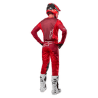 Alpinestars 2024 Racer Hoen Pants e maglia coordinata in Mars Red Burgundy, vista posteriore di un pilota di motocross in equipaggiamento completo con casco rosso e stivali bianchi, che mostra la vestibilità atletica e il branding per il racing fuoristrada.