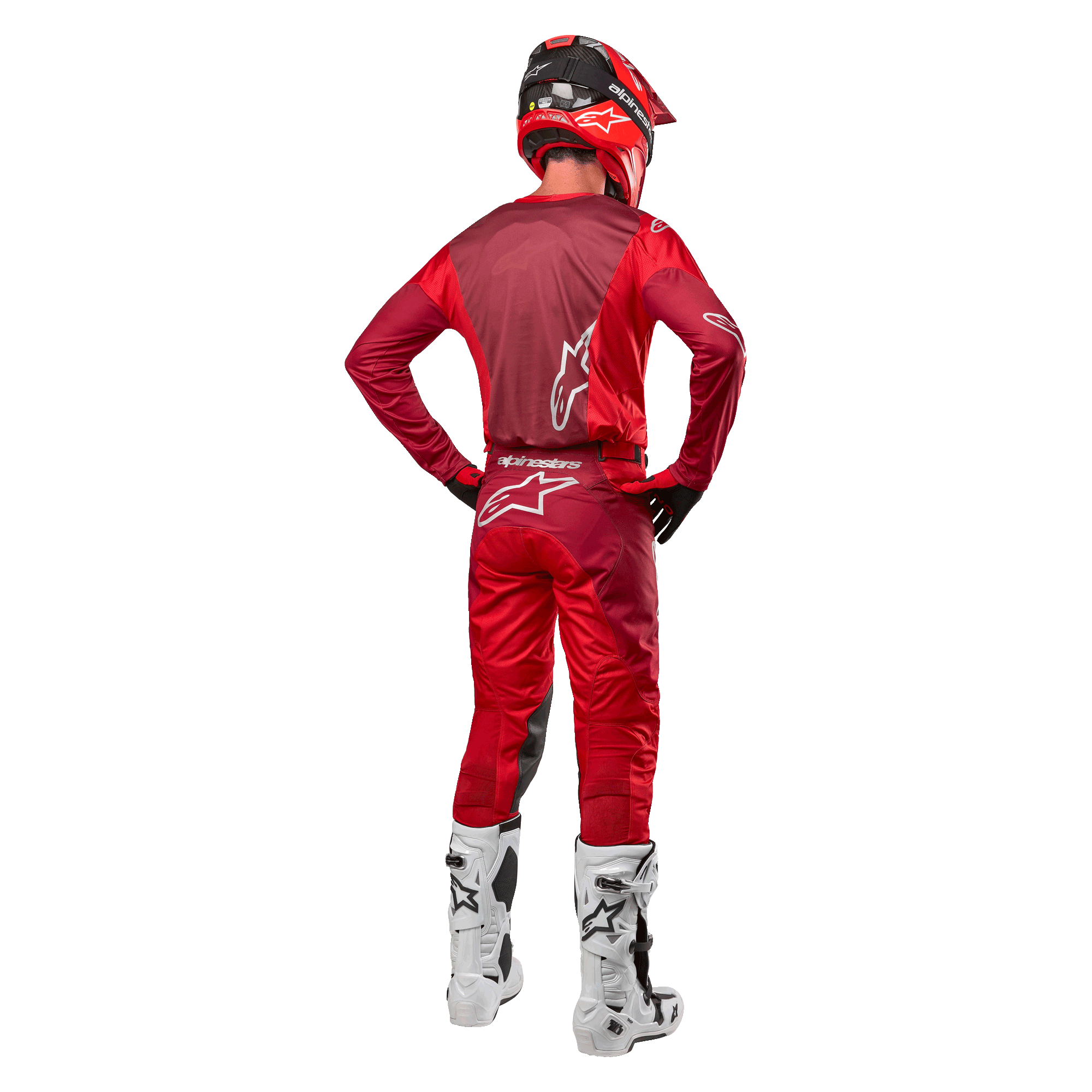 Alpinestars 2024 Racer Hoen Pants e maglia coordinata in Mars Red Burgundy, vista posteriore di un pilota di motocross in equipaggiamento completo con casco rosso e stivali bianchi, che mostra la vestibilità atletica e il branding per il racing fuoristrada.