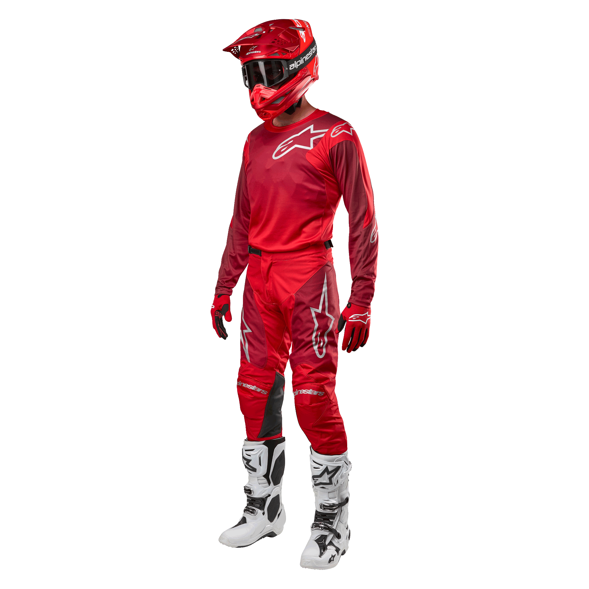 Pilota di motocross con equipaggiamento completo da gara, pantaloni e maglia Alpinestars Racer Hoen 2024 in Mars Red Burgundy, casco rosso, guanti rossi e stivali bianchi e neri, completo coordinato per il fuoristrada