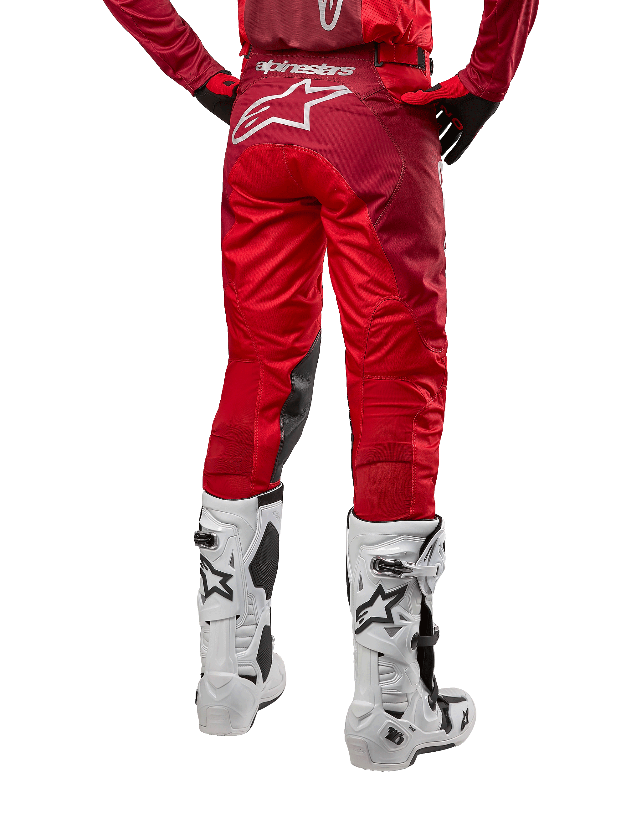 Alpinestars 2024 Racer Hoen Pants, pantaloni da motocross, Mars Red Burgundy, vista posteriore con grande logo Astar bianco sul retro, pannelli interni neri sulle ginocchia, indossati con stivali da motocross bianchi, abbigliamento tecnico per fuoristrada
