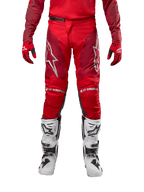 Alpinestars pantaloni Racer Hoen 2024, pantaloni da motocross, Mars Red Burgundy, vista frontale con loghi Alpinestars argento e branding sulle ginocchia, indossati con maglia rossa coordinata, guanti rossi e neri e stivali off-road bianchi.