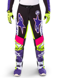 Alpinestars Limited Edition Supertech Dirt Studios Pants, pantaloni da motocross, bianco, viola e giallo fluo, con pannelli neri e accenti giallo neon e rosa, grandi loghi a stella viola, mostrati con guanti giallo neon e stivali da corsa viola coordinati, abbigliamento da corsa fuoristrada resistente