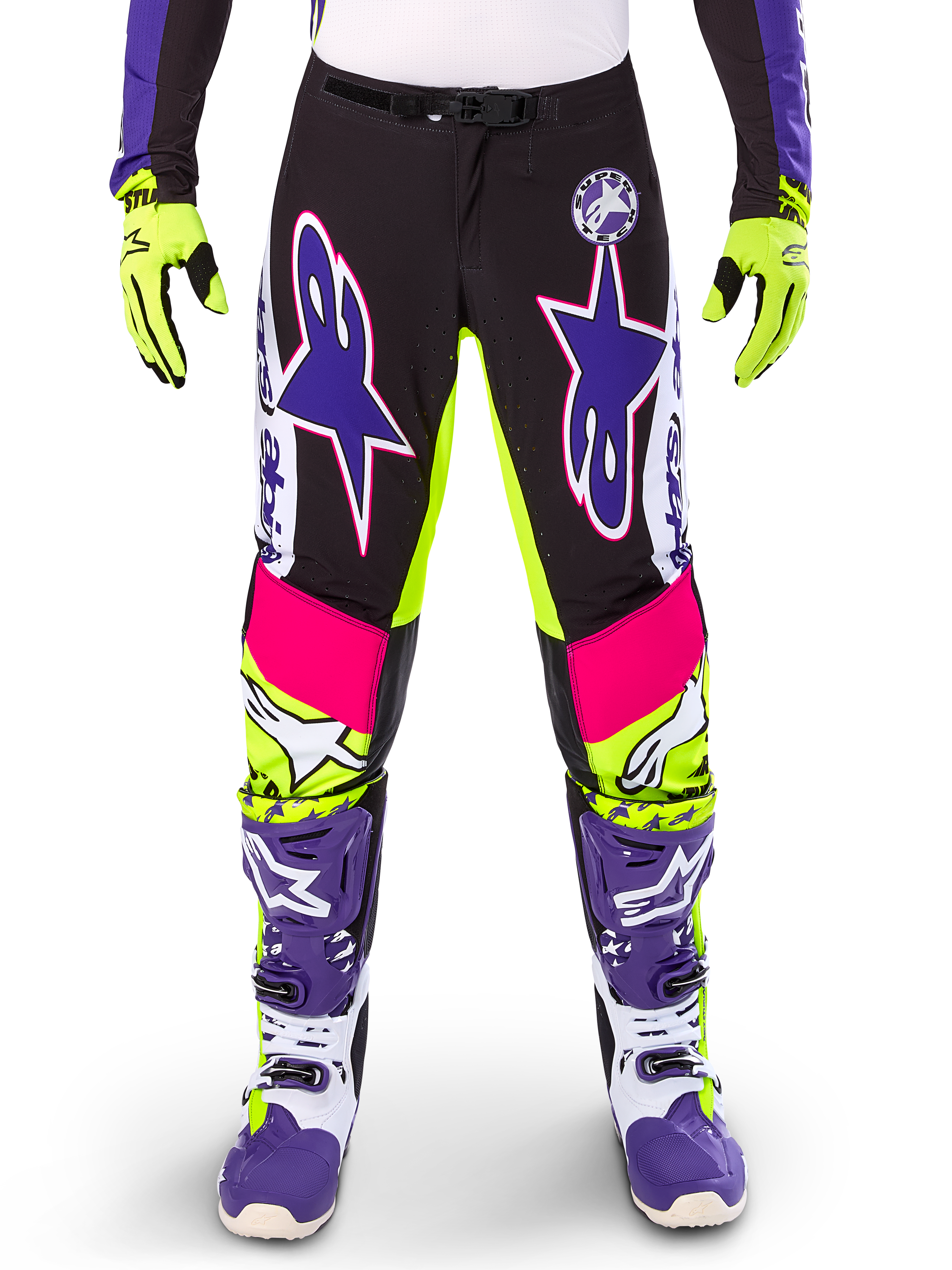 Alpinestars Limited Edition Supertech Dirt Studios Pants, pantaloni da motocross, bianco, viola e giallo fluo, con pannelli neri e accenti giallo neon e rosa, grandi loghi a stella viola, mostrati con guanti giallo neon e stivali da corsa viola coordinati, abbigliamento da corsa fuoristrada resistente