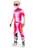 Pilota di motocross con set completo Alpinestars Supertech AFD MIG Limited Edition, maglia e pantaloni con sfumatura rosa fluo, bianco e arancione, casco bianco con occhiali arancioni, stivali bianchi e neri, abbigliamento professionale da fuoristrada
