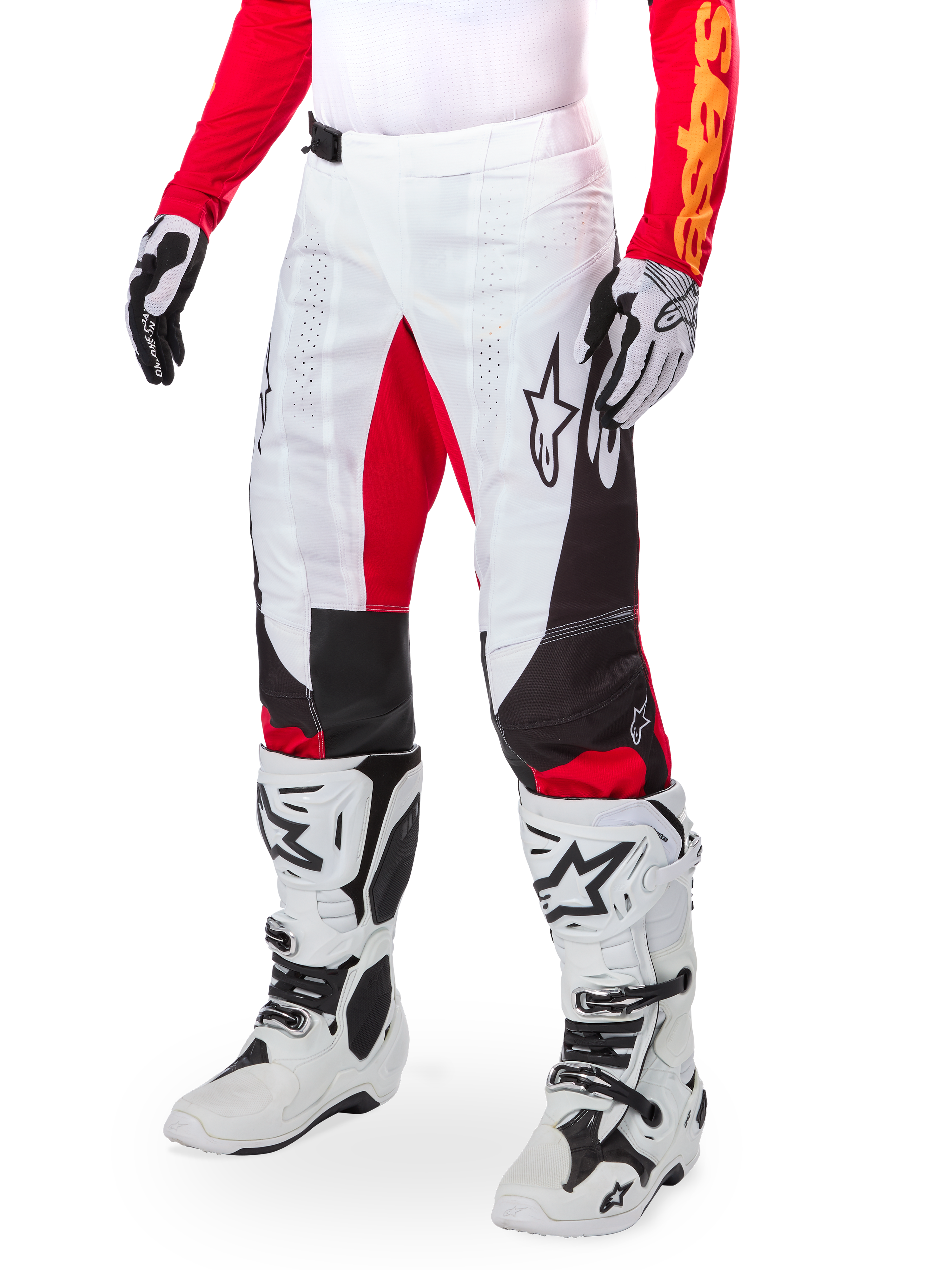 Alpinestars Limited Edition Techstar Deep Pants, pantaloni da motocross, bianco, nero e rosso acceso, indossati con stivali e guanti bianchi e neri, caratterizzati da pannelli frontali bianchi con accenti rossi e dettagli laterali neri, ideati per gare fuoristrada ad alte prestazioni