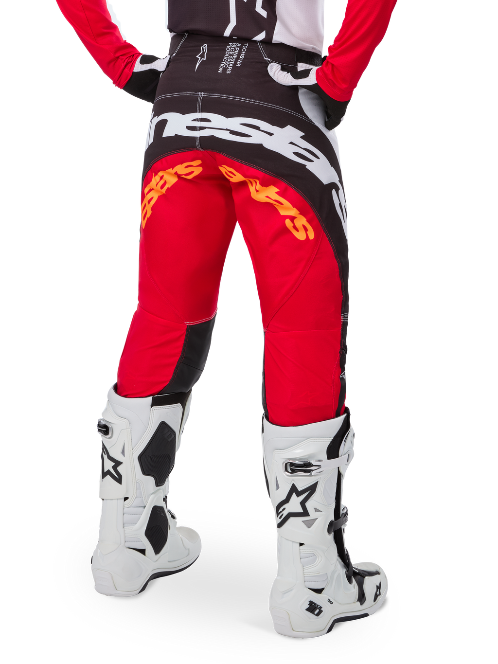 Alpinestars Techstar Deep Pants Edizione Limitata, pantaloni da motocross, nero, bianco e rosso acceso, vista posteriore con grande logo Alpinestars bianco sulla seduta e dettagli arancioni, indossati con stivali tecnici bianchi per competizioni fuoristrada professionistiche.