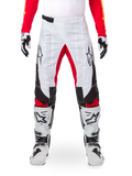 Pantaloni Alpinestars Limited Edition Techstar Deep, pantaloni da motocross, nero, bianco e rosso acceso, indossati con maglia rossa coordinata, guanti e stivali bianchi e neri, caratterizzati da pannelli anteriori bianchi, accenti rossi all'interno della gamba, pannelli laterali neri, loghi Alpinestars sulle cosce e dettagli traforati al laser per la ventilazione.