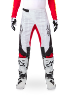 Pantaloni Alpinestars Limited Edition Techstar Deep, pantaloni da motocross, nero, bianco e rosso acceso, indossati con maglia rossa coordinata, guanti e stivali bianchi e neri, caratterizzati da pannelli anteriori bianchi, accenti rossi all'interno della gamba, pannelli laterali neri, loghi Alpinestars sulle cosce e dettagli traforati al laser per la ventilazione.