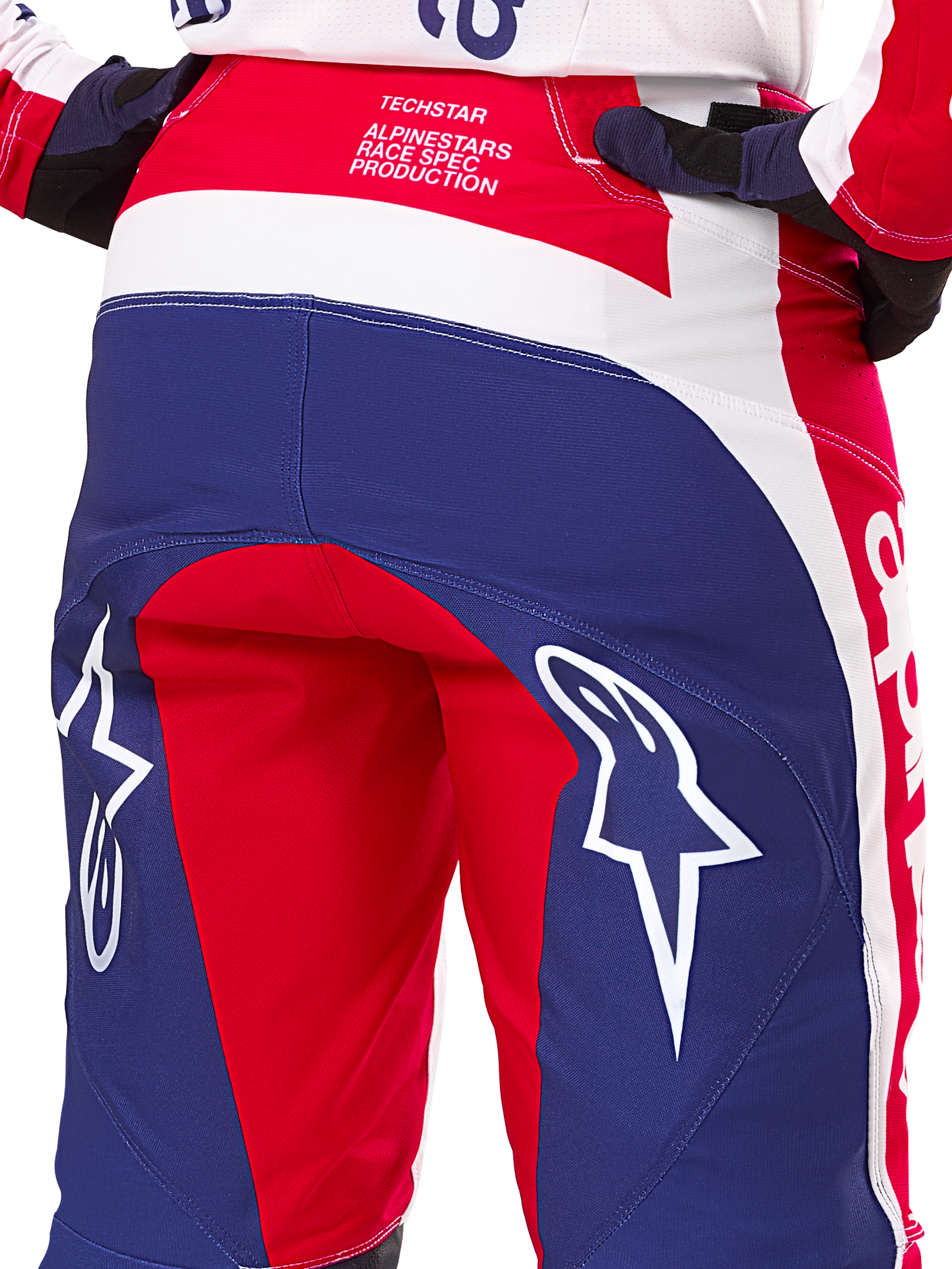 Pantaloni Alpinestars Limited Edition Techstar Fortitude, pantaloni da motocross, rosso, bianco e blu, vista posteriore con grandi loghi a stella bianchi sulla seduta e marchio Techstar Race Spec, tessuti tecnici resistenti per gare fuoristrada