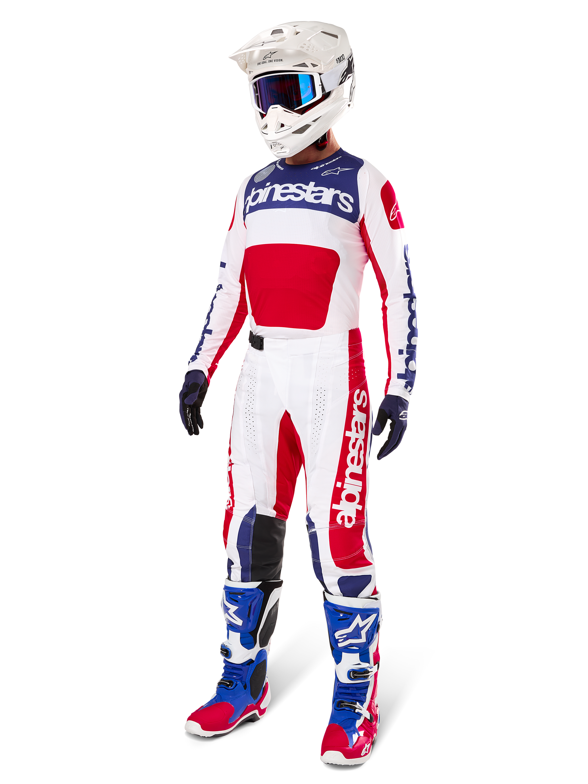 Pantaloni Alpinestars Techstar Fortitude Edizione Limitata, completo da motocross, rosso, bianco e blu, indossati con maglia abbinata, casco bianco, maschera blu e stivali blu e rossi, abbigliamento da gara professionale coordinato per competizioni fuoristrada