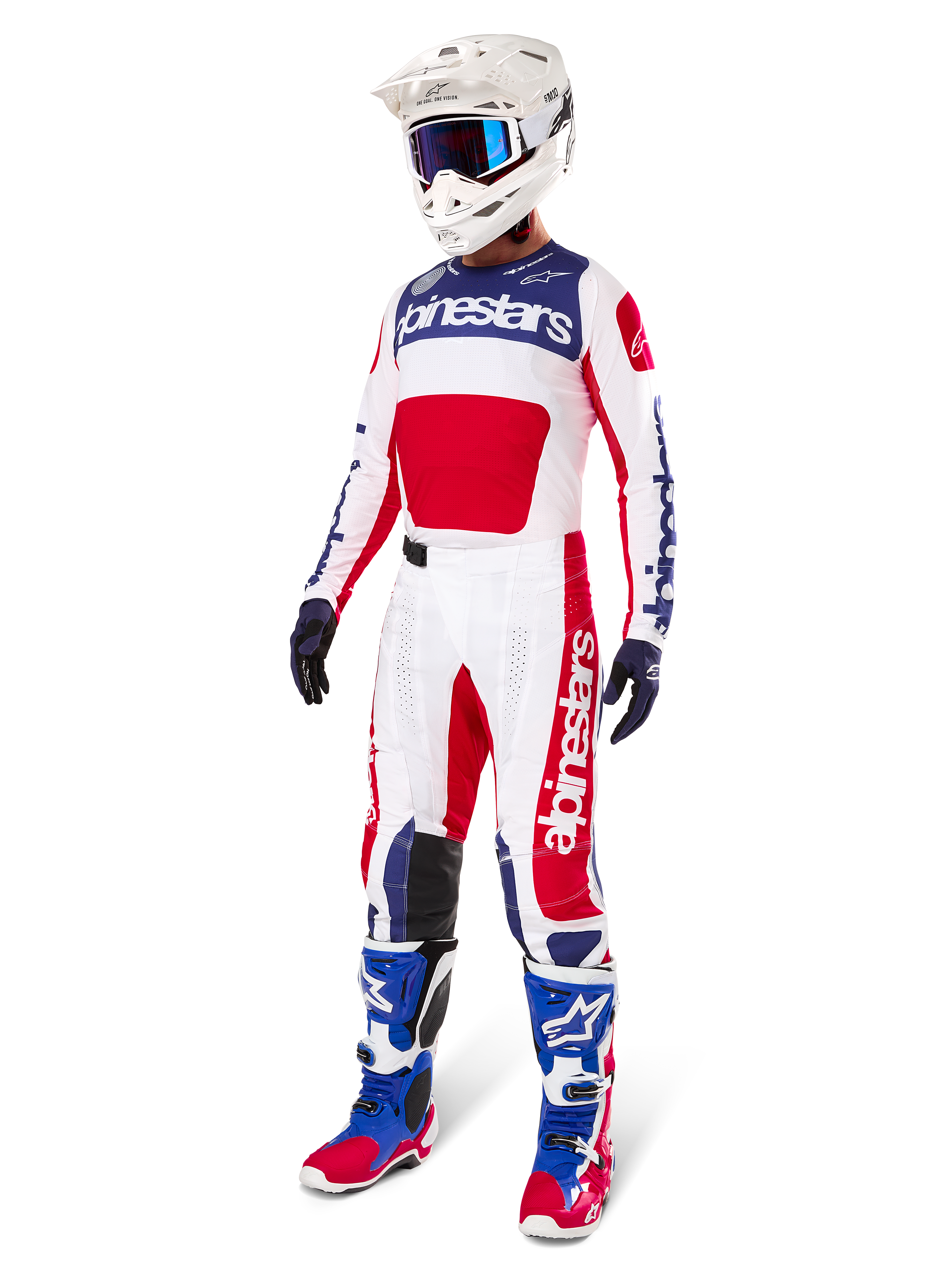 Pantaloni Alpinestars Techstar Fortitude Edizione Limitata, completo da motocross, rosso, bianco e blu, indossati con maglia abbinata, casco bianco, maschera blu e stivali blu e rossi, abbigliamento da gara professionale coordinato per competizioni fuoristrada