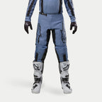 Alpinestars Pantaloni Fluid Lurv 2024, pantaloni da motocross, azzurro e nero, indossati con stivali da corsa bianchi e neri e guanti coordinati, con vistosi loghi a stella neri sulle cosce, design ergonomico per prestazioni off-road