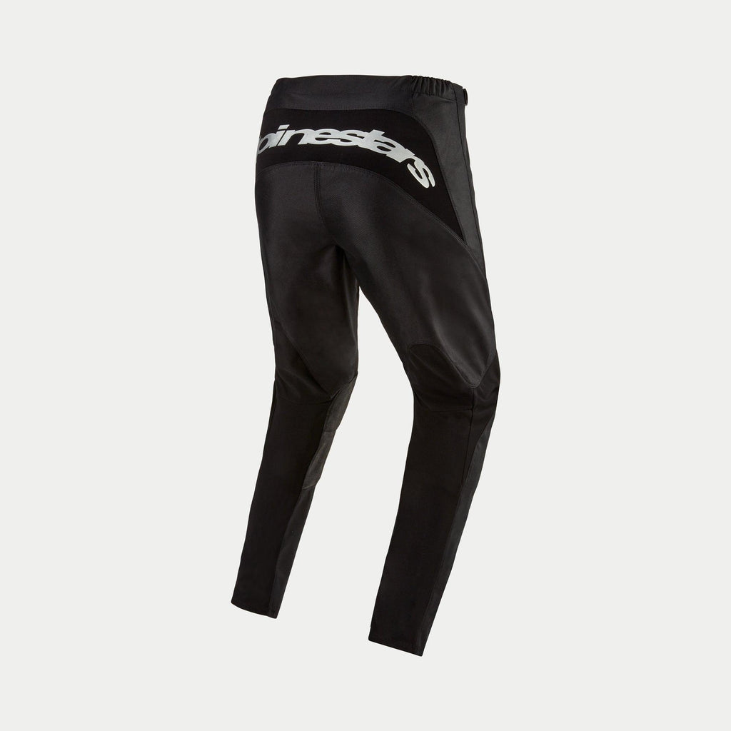 Alpinestars 2024 Fluid Graphite Pants, pantaloni da motocross, nero e argento, vista posteriore con logo Alpinestars argento sul retro yoke, design sportivo con pannelli rinforzati, resistente poli-tessuto per corse fuoristrada