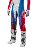 Alpinestars Pantaloni Techstar Pneuma 2024, pantaloni da motocross, Blu Mars Rosso Bianco, indossati con maglia coordinata, stivali da gara e guanti bianchi, design grafico vivace con accenti rossi, blu e viola, traforati per la traspirabilità