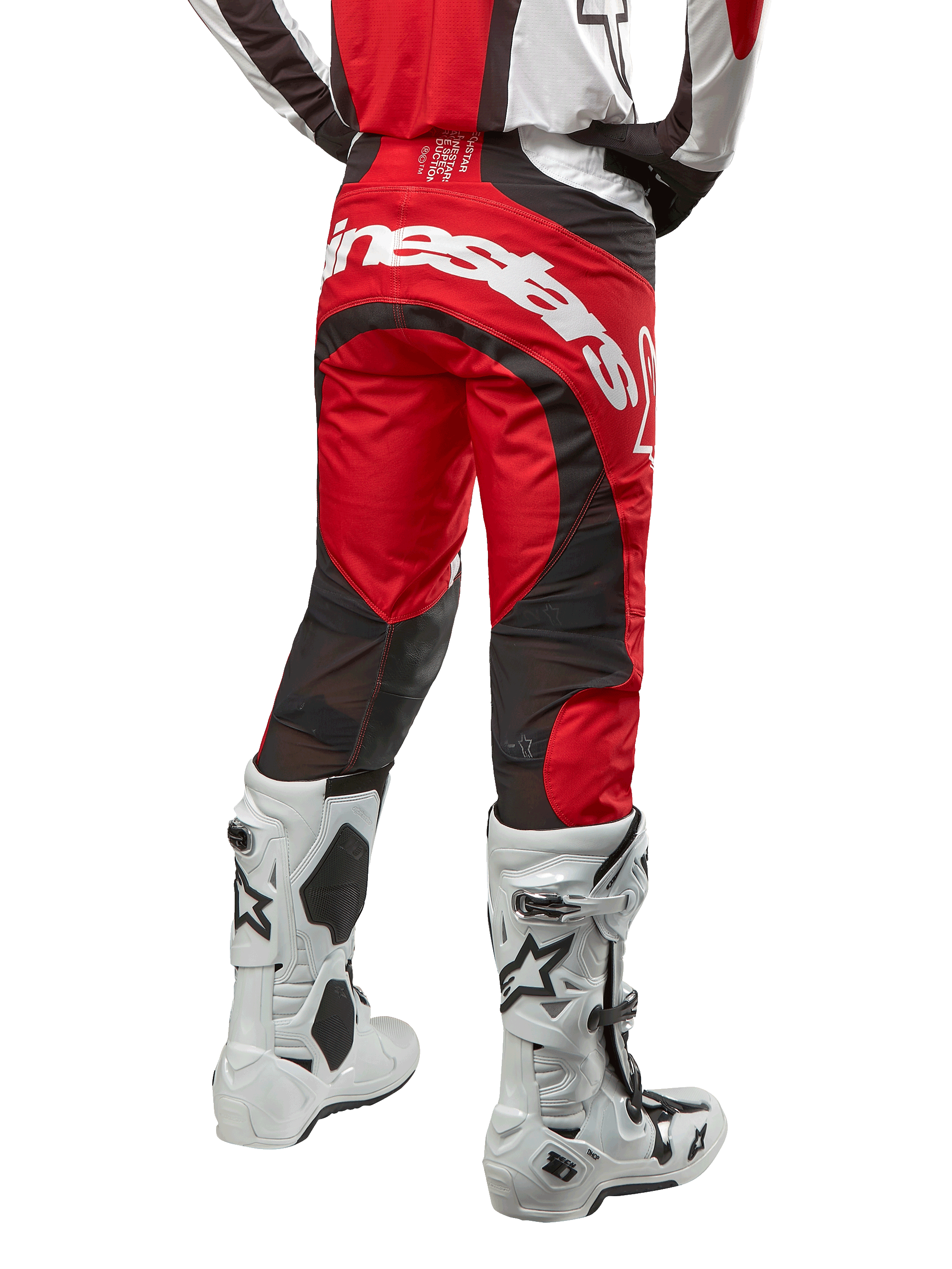 Alpinestars 2024 Techstar Ocuri Pants, pantaloni da motocross, Mars Red, bianco e nero, vista posteriore con grande logo Alpinestars bianco sulla seduta, pannelli di ventilazione in mesh nero, indossati con stivali da motocross bianchi e neri, design atletico race-fit per la guida off-road