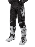 Alpinestars 2024 Racer Hana Pants, pantaloni da motocross neri con loghi bianchi, abbinati a stivali bianchi e guanti neri, abbigliamento sportivo per fuoristrada
