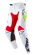 Alpinestars Pantaloni Racer Hana 2024, pantaloni da motocross, bianco multicolore, con pannelli interni alle ginocchia rossi e neri, loghi Astars blu e branding giallo neon, design pre-curvato con chiusura a cricchetto, abbigliamento resistente per corse fuoristrada