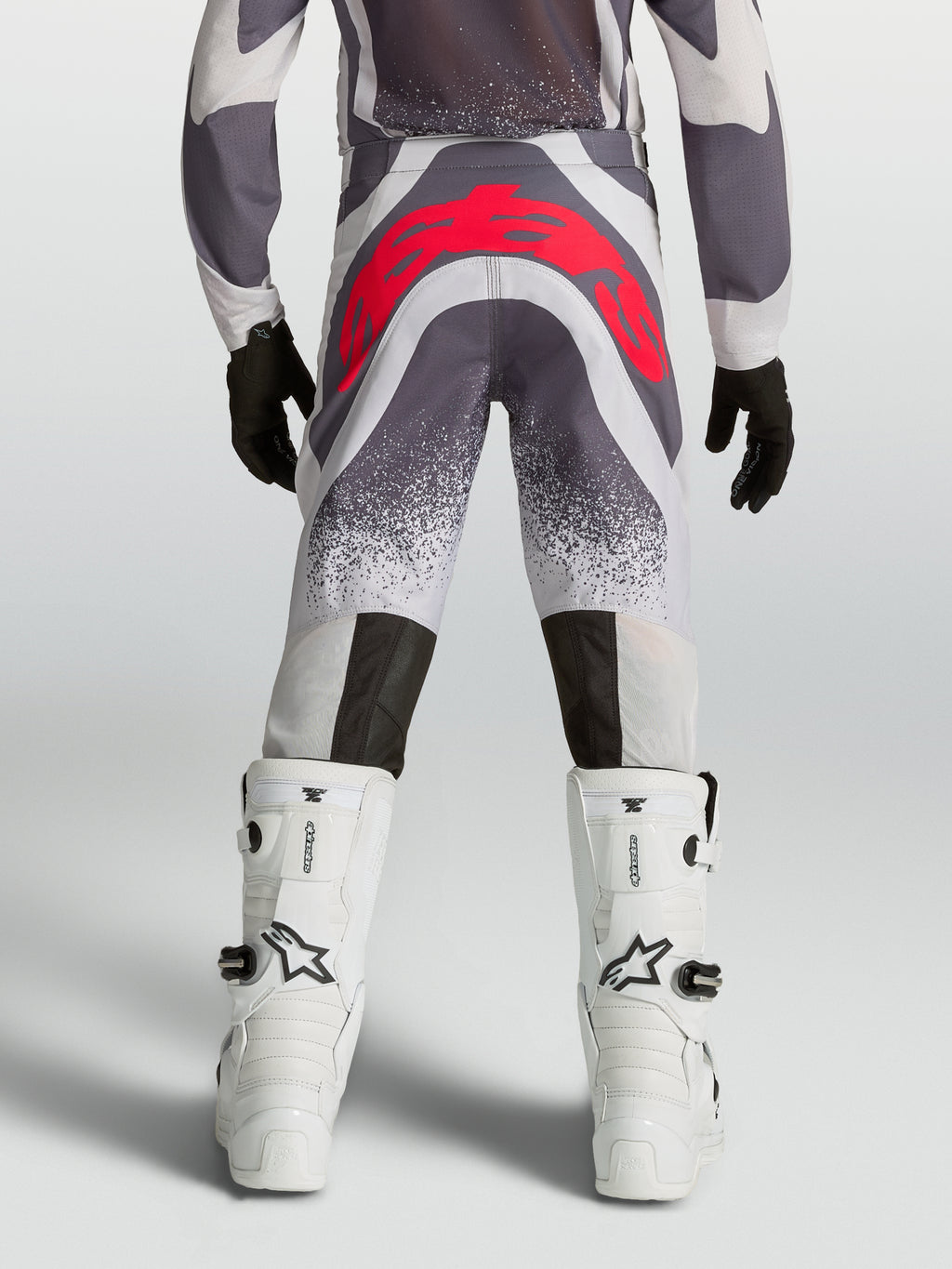 Alpinestars Pantaloni Supertech Swan Ragazzo, pantaloni motocross grigi e rosso fluo, vista posteriore atletica