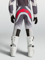 Alpinestars Pantaloni Supertech Swan Ragazzo, pantaloni motocross grigi e rosso fluo, vista posteriore atletica