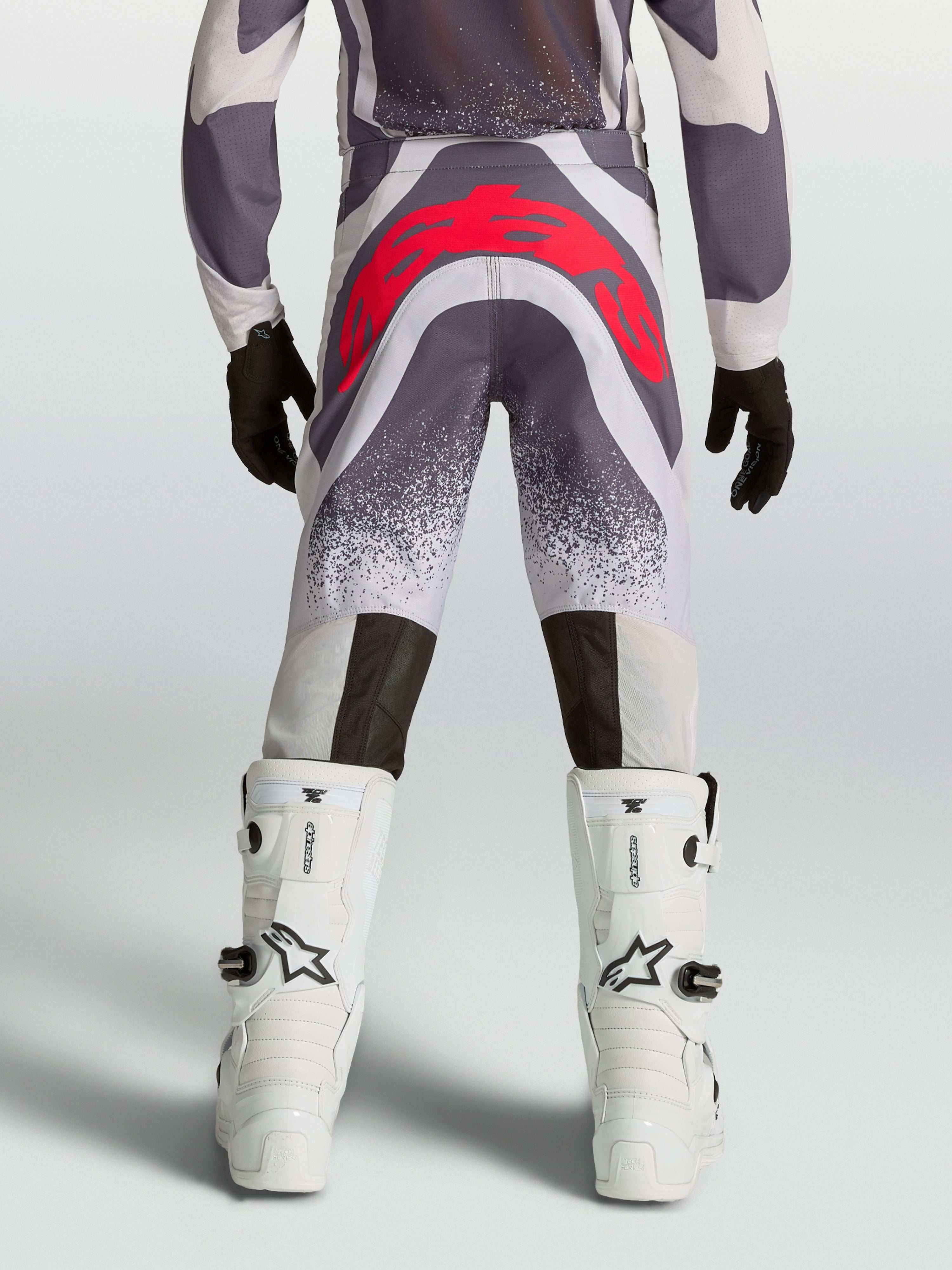 Alpinestars Pantaloni Supertech Swan Ragazzo, pantaloni motocross grigi e rosso fluo, vista posteriore atletica