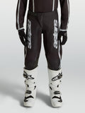 Pantaloni motocross Alpinestars Fluid Apex V2 Ragazzo, neri e argento, in polytessuto 600D con gambe precurvate.