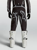 Alpinestars Pantaloni Fluid Apex V2 Ragazzo, neri e argento, abbigliamento motocross con loghi a stella e taglio ergonomico.
