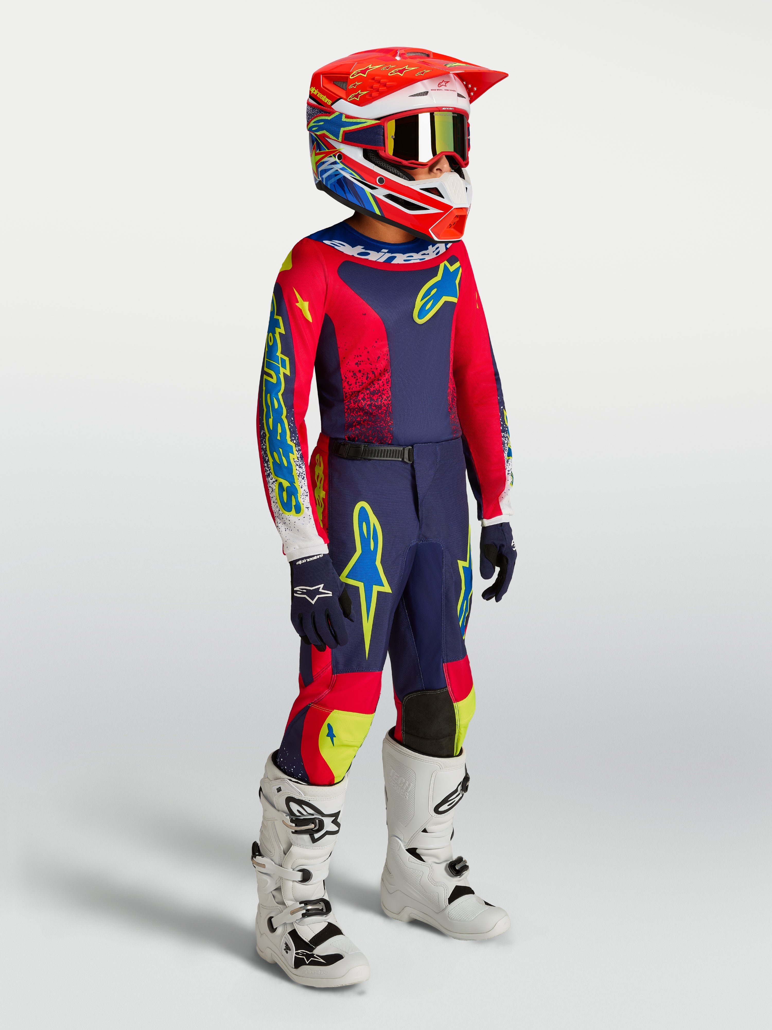 Pantaloni Alpinestars Fluid Drag Ragazzo, pantaloni da motocross per giovani piloti, blu navy e rosso, indossati come parte di un completo da gara fuoristrada