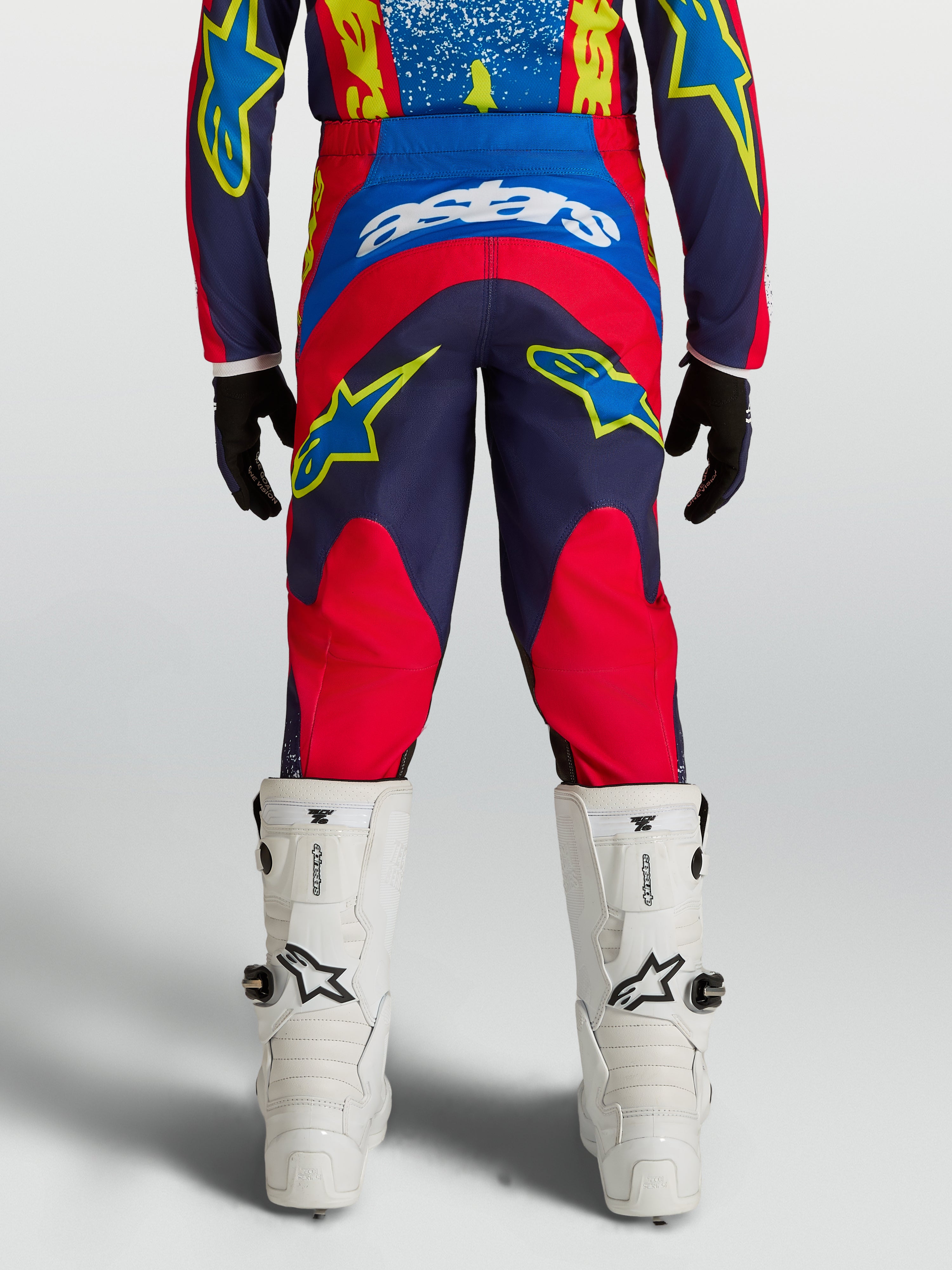 Alpinestars Pantaloni Fluid Drag Ragazzo, pantaloni motocross racing blu navy e rosso, vista posteriore ergonomica su modello.